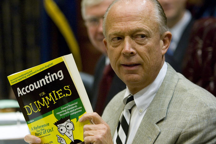 South Carolina Comptroller General Richard Eckstrom holds up a book he wanted to present to his new chief of staff James Holly during his introduction a meeting on Aug. 13, 2009, in Columbia, S.C. Eckstrom is stepping down from his post after a $3.5 billion accounting error.