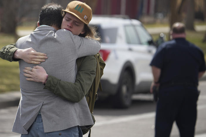 A student hugs a man after a school shooting at East High School Wednesday in Denver.