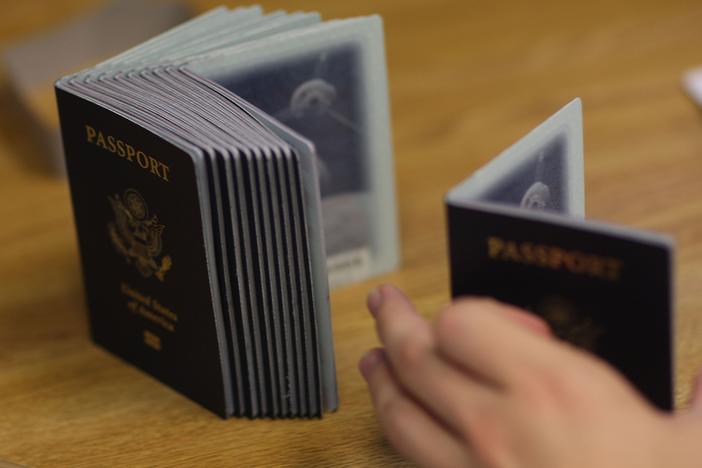 A Passport Processing employee uses a stack of blank passports to print a new one at the Miami Passport Agency June 22, 2007 in Miami, Fla. Passport processing times are high due to increased demand.