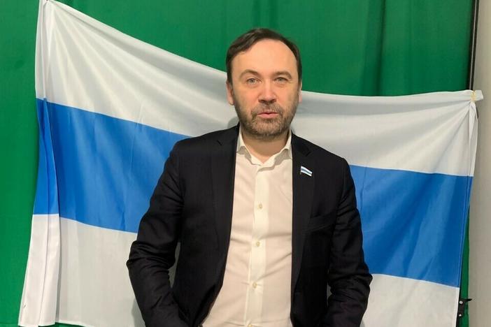 Ilya Ponomarev is the founder of February Morning, an opposition Russian-language online newscast aimed at viewers in Russia. Behind him is a flag symbolizing the "free Russia of the future," created following Russia's 2022 invasion of Ukraine. Ponomarev calls it the "Russian tricolor without the blood."
