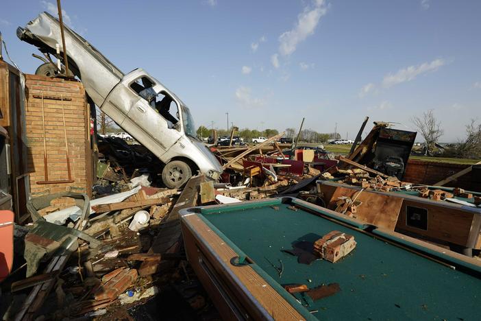 A pickup truck rests on top of a restaurant cooler at Chuck's Dairy Cafe in Rolling Fork, Miss. Emergency officials in Mississippi say several people have been killed by a tornado that tore through the state on Friday night, destroying buildings and knocking out power as severe weather produced hail the size of golf balls moved through several southern states.