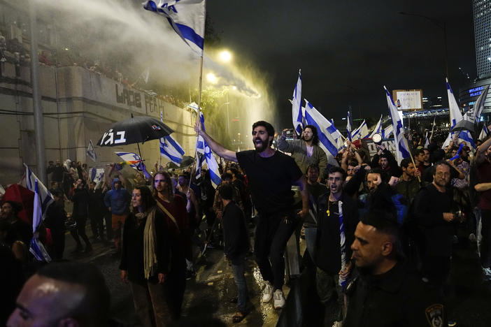 Israeli police use a water cannon to disperse demonstrators blocking the freeway during a protest against plans by Prime Minister Benjamin Netanyahu's government to overhaul the judicial system in Tel Aviv, Israel, on Saturday.