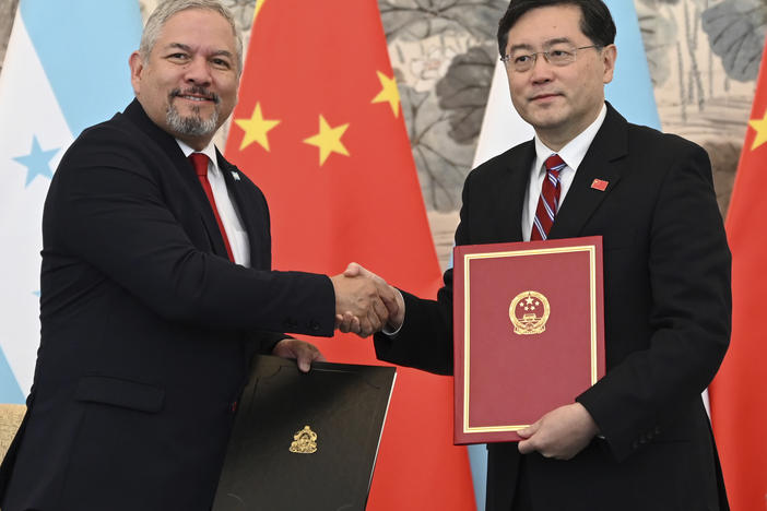 Honduras Foreign Minister Eduardo Enrique Reina Garcia, left, and Chinese Foreign Minister Qin Gang shake hands following the establishment of diplomatic relations between the two countries, at a ceremony in the Diaoyutai State Guesthouse in Beijing Sunday, March 26, 2023.