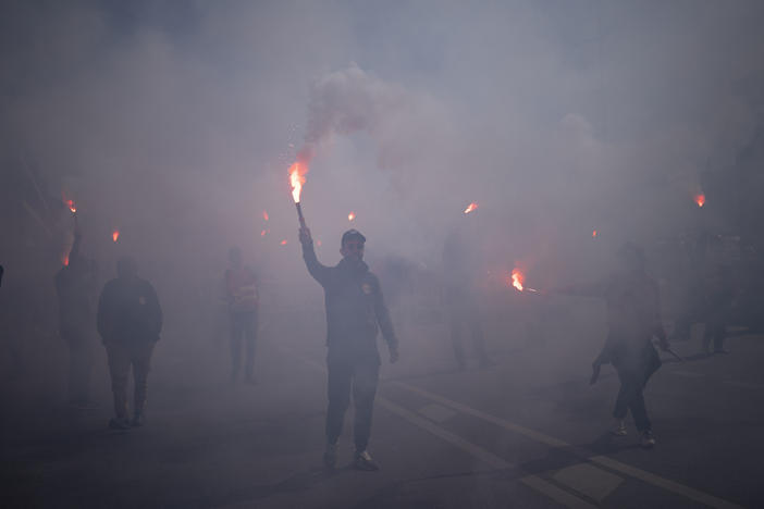 Protesters march with flares during a demonstration in Marseille, southern France, on Tuesday. France's government is unfurling massively ramped-up security measures for a fresh blast of marches and strikes against unpopular pension reforms.