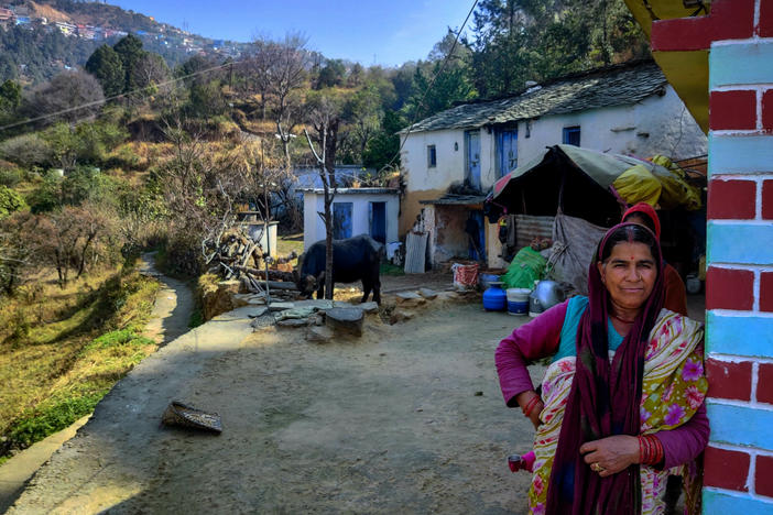 Krishna Lal stands in front of her house. The town of Chamba is on the hill behind her.