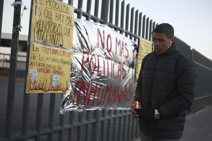 A man holds a candle during a vigil on Tuesday for the victims of a fire at an immigration detention center that killed dozens, in Ciudad Juarez, Mexico. Video footage from inside the facility appears to show officials walking away from men trapped inside a cell as flames roared around them.