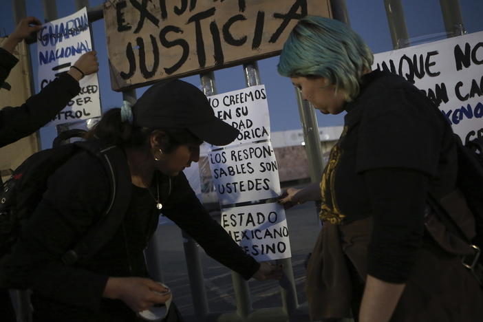 Activists post signs Wednesday as they protest outside a migration detention center in Ciudad Juarez, Mexico, a day after dozens of migrants died as a result of the fire.