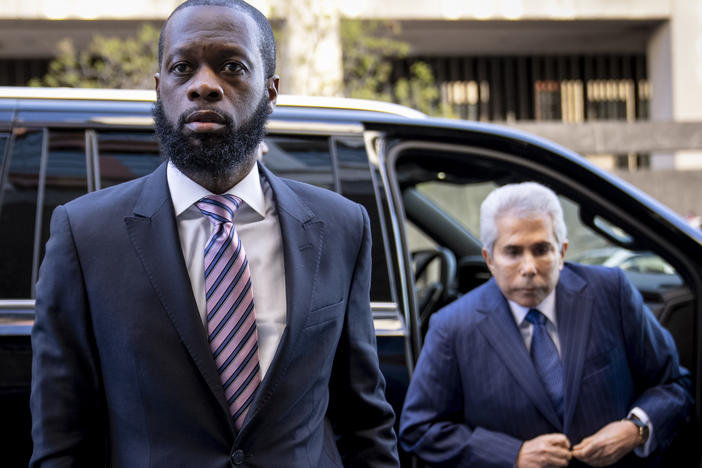 Prakazrel "Pras" Michel, left, a member of the 1990s hip-hop group the Fugees, accompanied by defense lawyer David Kenner, right, arrives at federal court for his trial on March 30.