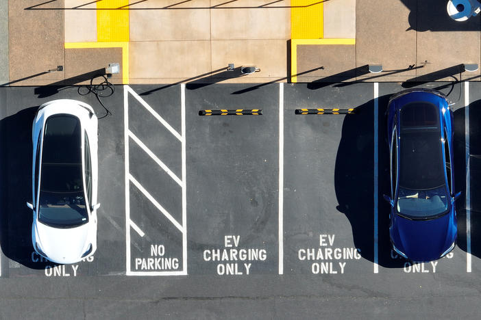 In an aerial view, Tesla cars recharge at a Tesla charger station in Corte Madera, Calif., on Feb. 15, 2023. The Biden administration wants to boost sales of electric cars, but it also wants to incentivize U.S.-based production.