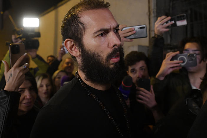Young fans and media surround Andrew Tate as he leaves a police detention facility in Bucharest, Romania, after his release from prison on Friday.