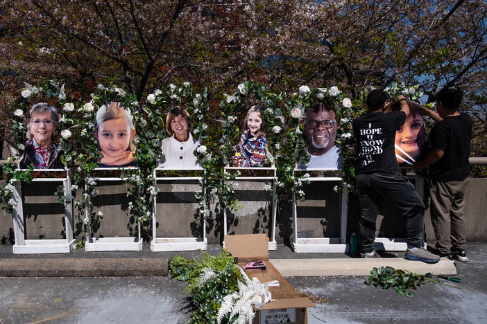 Pictures of the victims killed in a mass shooting on Monday at the Covenant School in Nashville, Tenn., are fixed to a memorial by Noah Reich (left) and David Maldonado, from the nonprofit Classroom of Compassion, near the school on Wednesday.