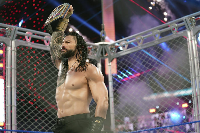 Roman Reigns holds up the WWE Universal Championship belt after defeating Jey Uso during an October 2020 match in Orlando, Fla.