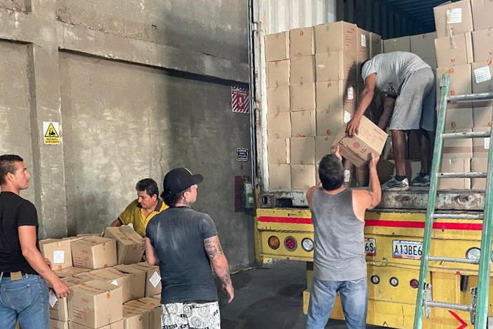 Workers unload boxes of mayonnaise for inspection by customs officials at a warehouse in the Venezuelan border town of San Antonio del Táchira.
