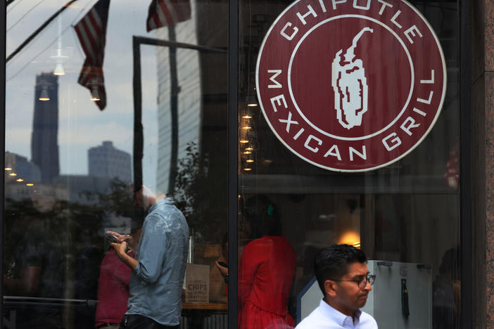 People walk past a Chipotle store in New York City. The fast casual restaurant known for its burritos and bowls is suing Sweetgreen over alleged trademark infringement.