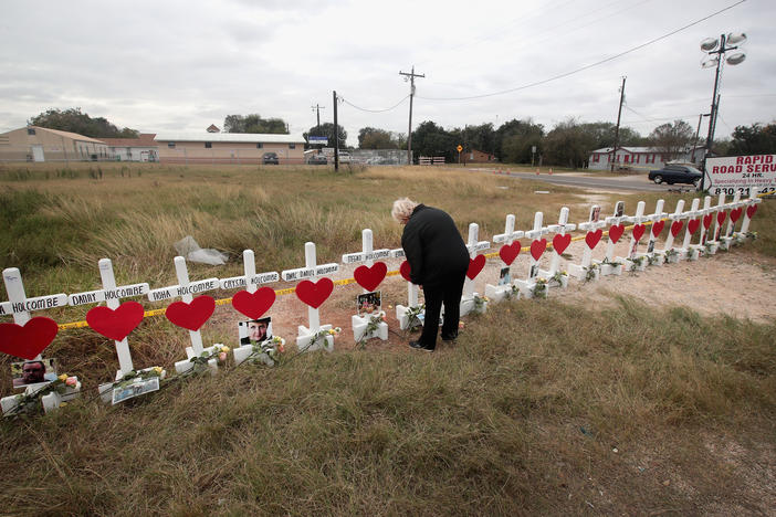 Helen Biesenbach leaves a message at a memorial where 26 crosses were placed to honor the victims killed at the First Baptist Church of Sutherland Springs on November 9, 2017 in Sutherland Springs, Texas.