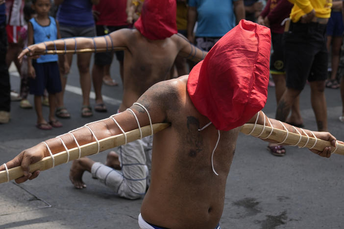 Hooded Filipino penitents carry pointed bamboo sticks as part of Maundy Thursday rituals to atone for sins or fulfill vows for an answered prayer on April 6, 2023 at Mandaluyong city, Philippines.