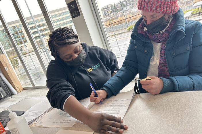 JustCARE outreach worker Kendra Tate (left) helps Starr Draper complete paperwork necessary for her to move from a homeless encampment into a temporary home.