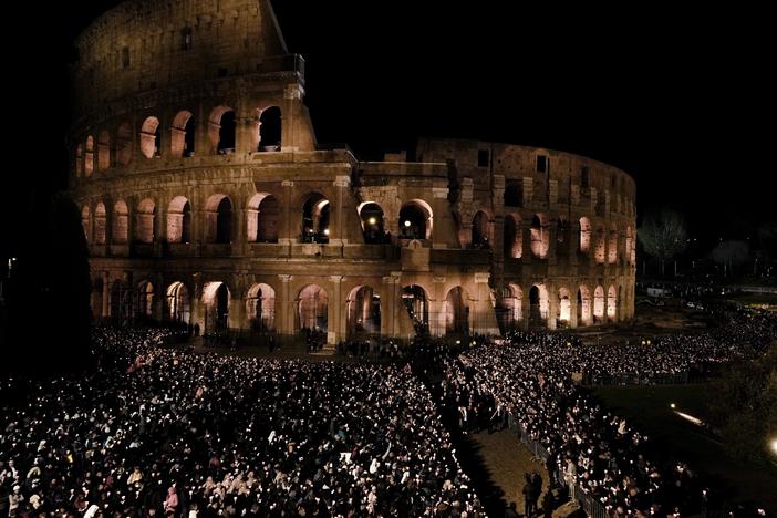 People hold candles during a Via Crucis (Way of the Cross) torchlight procession on Good Friday in Rome on Friday, April 7, 2023.