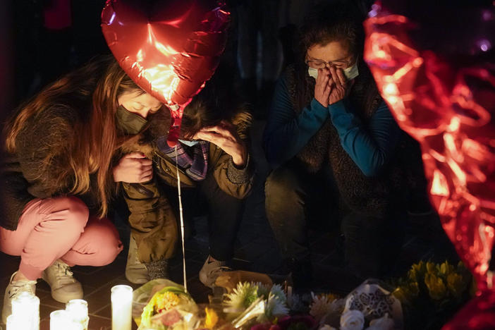 Women pause at a memorial at a vigil honoring the victims of a shooting at the Star Ballroom Dance Studio on Monday, Jan. 23, 2023, in Monterey Park, Calif.