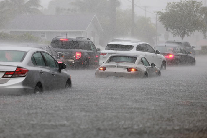 Cars are parked in a flooded street on Wednesday in Dania Beach, Florida.
