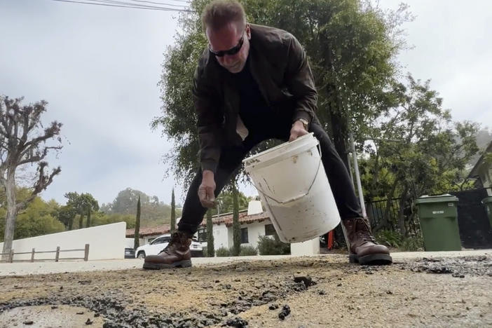 This video still image provided by The Office of Arnold Schwarzenegger, shows former California Governor Arnold Schwarzenegger, repairing what he called a pot hole on a street in his Los Angeles neighborhood on Tuesday, April 11, 2023.