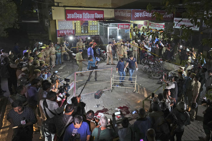 Police and media surround the area where Gangster-turned-politician Atiq Ahmad and his brother Ashraf were shot in front of the Motilal Nehru medical college in, Prayagraj, India, Saturday, April 15, 2023.