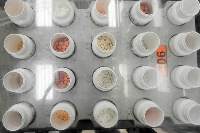 Bottles of prescription pills go through an automated packaging machine in a pharmacy plant. The Supreme Court on Tuesday hears a case that considers whether pharmacies knowingly overcharged Medicare and Medicaid under the False Claims Act.