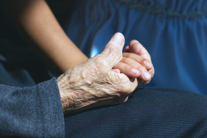 A girl holding her great-grandmother's hand. Japan has one of the world's most rapidly aging societies.