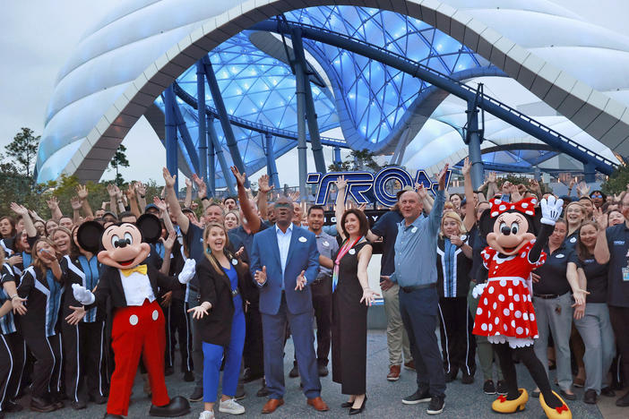 Mickey, Minnie and cast members join Walt Disney World executives in a ceremony marking the official opening of Tron Lightcycle / Run at the Magic Kingdom in early April.