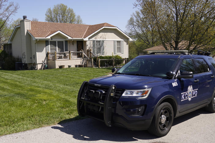 A police officer drives past the Kansas City home where 16-year-old Ralph Yarl was shot last week.