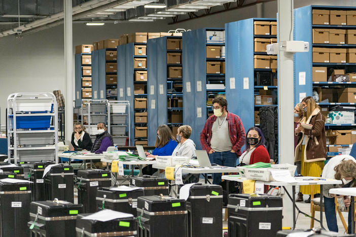 Gwinnett County election workers prepare to handle ballots as part of the recount for the 2020 presidential election on Nov. 16, 2020, in Lawrenceville, Georgia. Nearly two and a half years after the election, voting machine companies, election workers and even a local postmaster have filed defamation cases tied to conspiracy theories that have spread about the election.