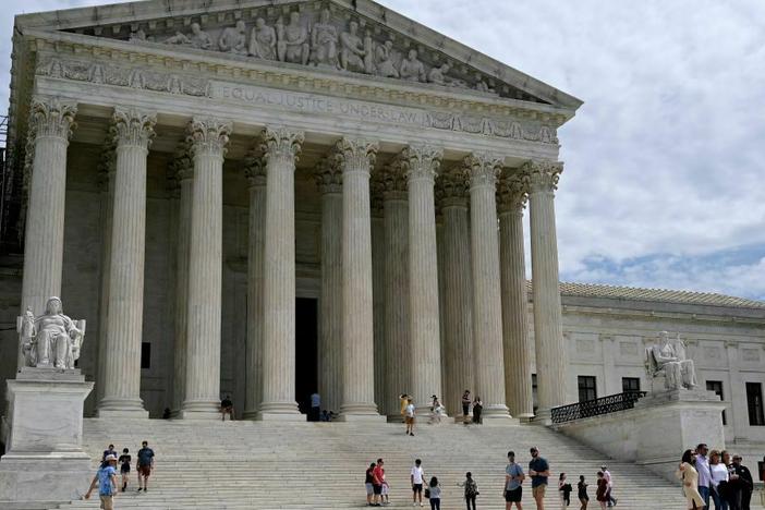 People walk outside the U.S. Supreme Court in Washington, D.C., on Friday.