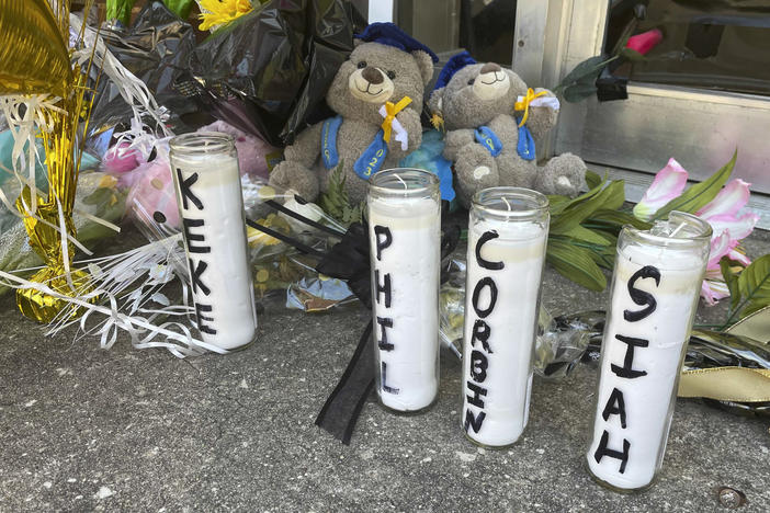 Candles with the names of the four young people killed in a shooting and teddy bears dressed in graduation caps sit outside the Mahogany Masterpiece dance studio on Wednesday, in Dadeville, Ala.