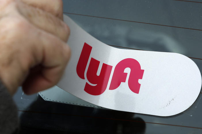 A Lyft logo is installed on a Lyft driver's car in Pittsburgh. The company announced this week that its making major cuts to its staff in a cost-saving move.