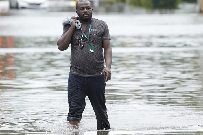 A man walks out of a flooded Fort Lauderdale neighborhood on April 13. Florida Gov. Ron DeSantis is asking the Biden administration to declare Broward County a disaster area due to flooding earlier this month after record rainfall.