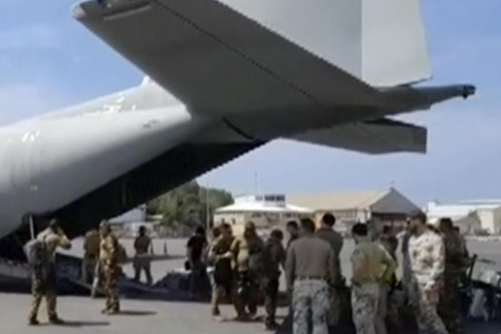 Italian Defense Ministry personnel prepare to evacuate foreign nationals from the airport in Khartoum on Sunday.