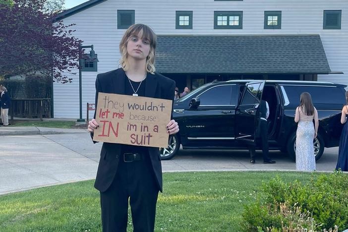 Hayes stood outside of the prom holding a sign that read, "they wouldn't let me in because i'm in a suit."