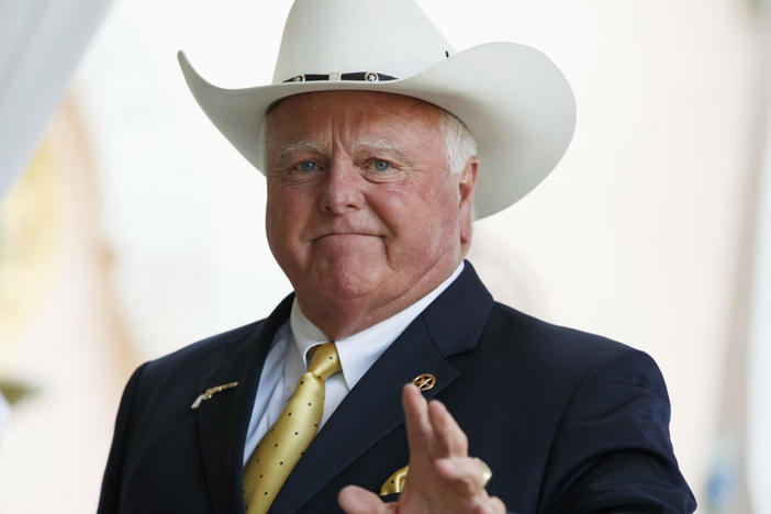 The Texas Department of Agriculture has handed down a new dress code for its employees — mandating they follow with it in a "manner consistent with their biological gender." Here in this Dec. 30, 2016, file photo, Texas Agriculture Commissioner Sid Miller waves as he arrives at Mar-a-Lago to meet with President-elect Donald Trump's transition team in Palm Beach, Fla.