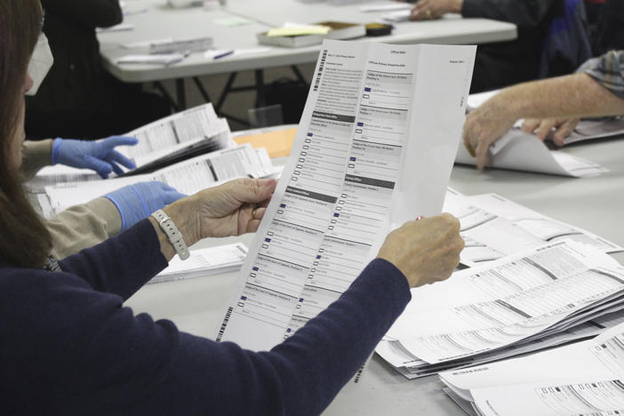 A worker examines a ballot at the Clackamas County elections office on May 19, 2022, in Oregon City, Ore. No Labels, a centrist group that has floated a bipartisan presidential ticket, has secured access to the ballot in Oregon and other states.