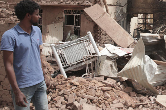 A man walks by a house hit in fighting in Khartoum, Sudan, on Tuesday.