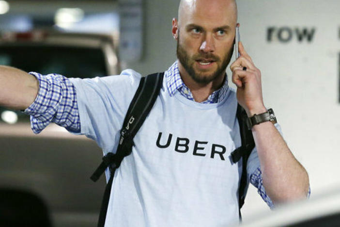 A senior operations manager for Uber directs drivers at the Seattle-Tacoma International Airport.