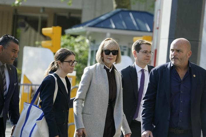 Writer E. Jean Carroll (center) arrives at Manhattan federal court on the first day of her defamation case against former President Donald Trump. She's accused him of raping her in a department store dressing room in the 1990s.