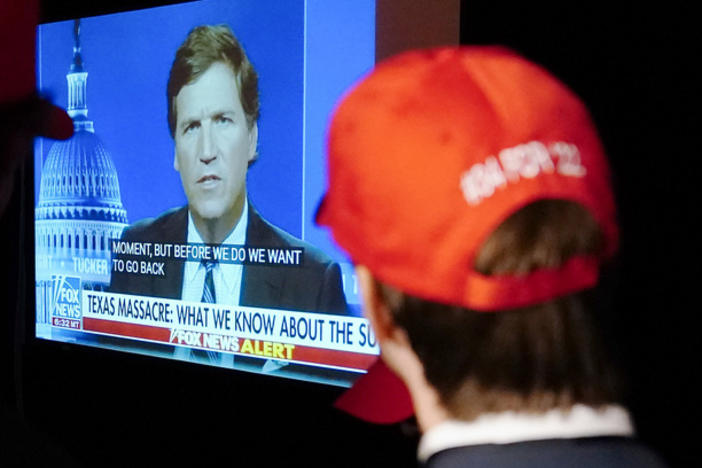 Supporters at a Herschel Walker election night watch party last year watching former Fox News host Tucker Carlson.