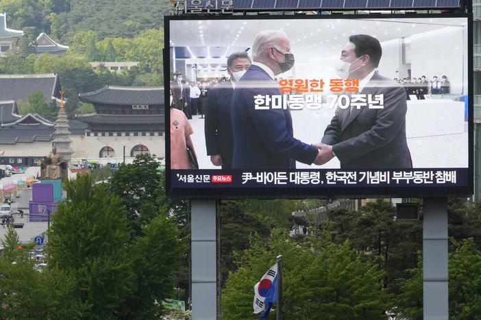 A screen on Wednesday shows a file image of U.S. President Biden, left, and South Korean President Yoon Suk Yeol marking the 70th anniversary of the South Korea-U.S. alliance in Seoul, South Korea.