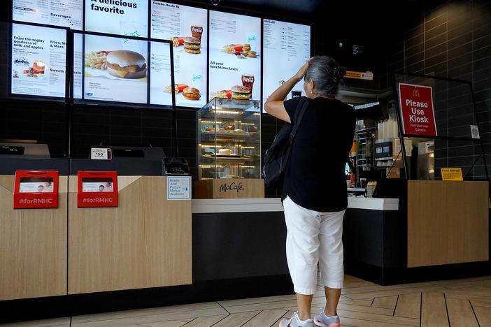 A customer waits to order food at a Miami McDonald's on July 26, 2022. The CEO of McDonald's expects the U.S. to experience a mild recession and says customers have grown more reluctant to splurge on or supersize their orders.