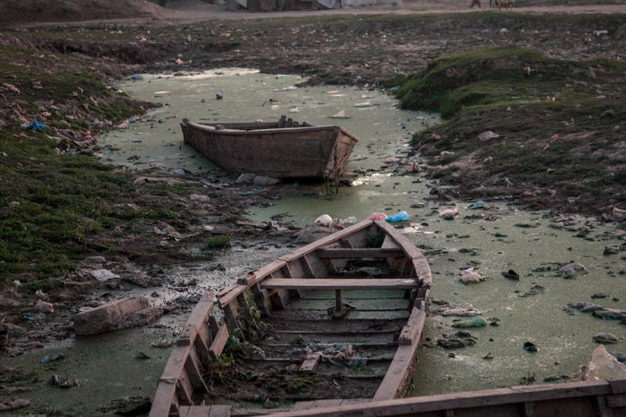 Traditional fishing boats rot in stagnant pools of water beside the Ravi River bank in the Pakistani city of Lahore.