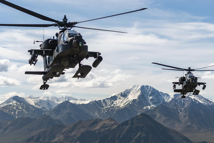 In this photo released by the U.S. Army, AH-64D Apache Longbow attack helicopters from the 1st Attack Battalion, 25th Aviation Regiment, fly over a mountain range near Fort Wainwright, Alaska, on June 3, 2019. The U.S. Army says two helicopters similar to these crashed on Thursday near Healy, Alaska, killing three soldiers and injuring a fourth.