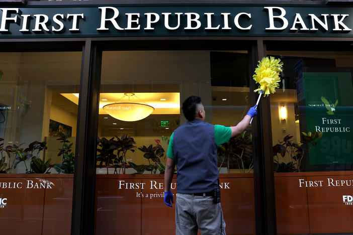 A worker cleans the outside of a First Republic bank in San Francisco. The lender was taken over by regulators and sold to JPMorgan Chase, marking the third bank failure in the country this year.