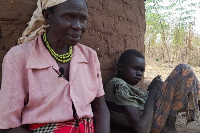 Ventorina Aculu of northern Uganda sits next to her adult son, Omac Alfred, who has a rare neurological disease known as nodding syndrome.