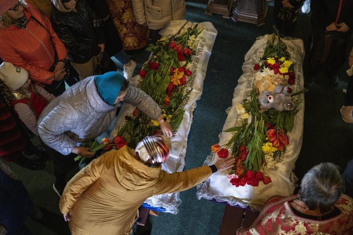 Mourners place flowers on the coffins of Sofia Shulha, 11, and Pysarev Kiriusha, 17, during a funeral in Uman, central Ukraine, Sunday. They were among more than 20 people killed during a Russian attack on a residential building early Friday morning.